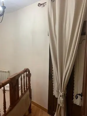 a curtain in a room next to a staircase at La Casa Verde de Sanabria de 3 habitaciones y 2 baños in Cerdillo