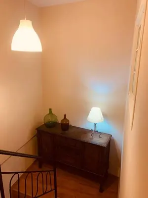 a room with a table with a lamp on it at La Casa Verde de Sanabria de 3 habitaciones y 2 baños in Cerdillo