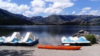 a group of boats parked on the shore of a lake at La Casa Verde de Sanabria de 3 habitaciones y 2 baños in Cerdillo
