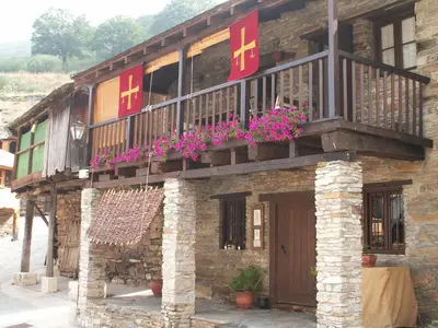a building with a balcony with flowers on it at Casa Turpesa in Peñalba de Santiago