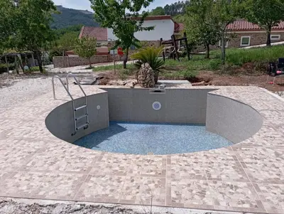 a circular pool in a patio with a fire pit at Hotel Donas e Cabaleiros in Pousada