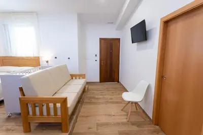a living room with a white couch and a chair at Hotel Donas e Cabaleiros in Pousada