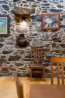 a stone wall with two chairs and a vase on it at Hotel Donas e Cabaleiros in Pousada