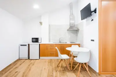 a kitchen with a table and white appliances at Hotel Donas e Cabaleiros in Pousada