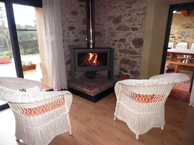 a living room with two chairs and a fireplace at Casa Fonte do Barro SPA opcional, de pago in Santiago de Compostela
