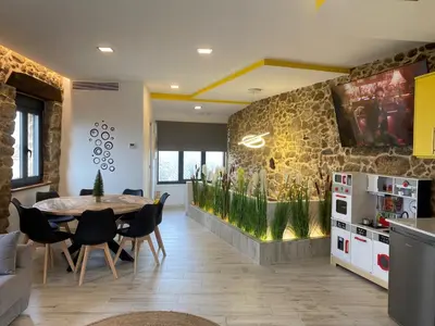 a dining room with a table and a fish tank at As Penedas, Casa dos Arcos in Sober