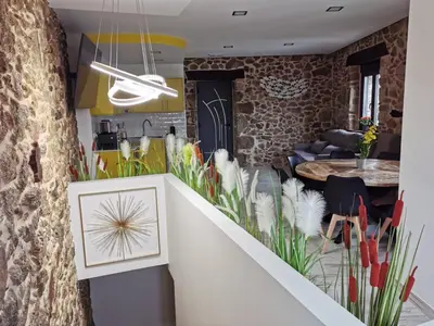a kitchen and dining room with a stone wall at As Penedas, Casa dos Arcos in Sober