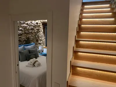 a bedroom with a bed next to a staircase at As Penedas, Casa dos Arcos in Sober