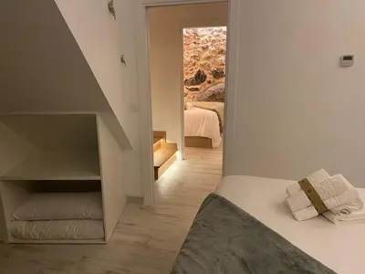 a room with a bed and a stairway leading to a bedroom at As Penedas, Casa dos Arcos in Sober