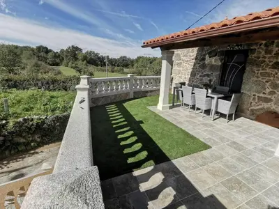 a patio with chairs and grass on a house at As Penedas, Casa dos Arcos in Sober