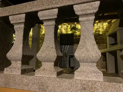 a stone railing with christmas lights in a window at As Penedas, Casa dos Arcos in Sober