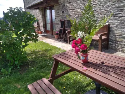 a wooden bench with a vase of flowers on it at La Posada de Oscos II in Santa Eulalia de Oscos