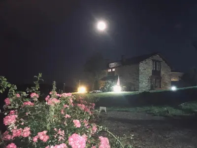 a stone house at night with a full moon at La Posada de Oscos II in Santa Eulalia de Oscos