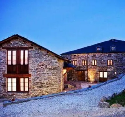 a large stone building with windows on it at La Posada de Oscos II in Santa Eulalia de Oscos