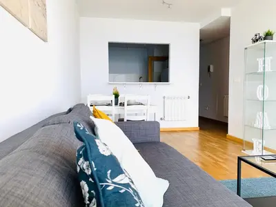 a living room with a gray couch and a table at Apartamentos LAMAROSA - DELUX -PARKING- in Burela de Cabo