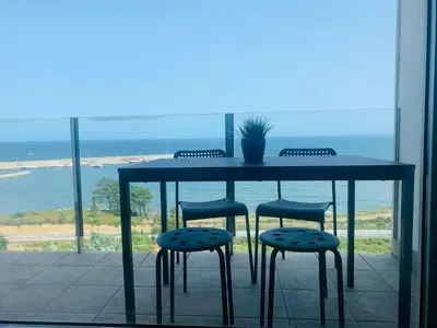 a table and chairs with a view of the ocean at Apartamentos LAMAROSA - DELUX -PARKING- in Burela de Cabo