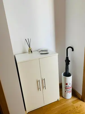 a white cabinet with an umbrella on top of it at Apartamentos LAMAROSA - DELUX -PARKING- in Burela de Cabo