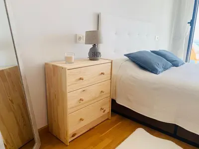 a bedroom with a bed and a dresser with a lamp at Apartamentos LAMAROSA - DELUX -PARKING- in Burela de Cabo
