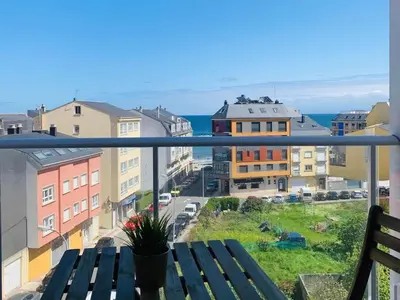 a balcony with a bench and a view of a city at Apartamentos LAMAROSA -PLAYA URBANA in Burela de Cabo