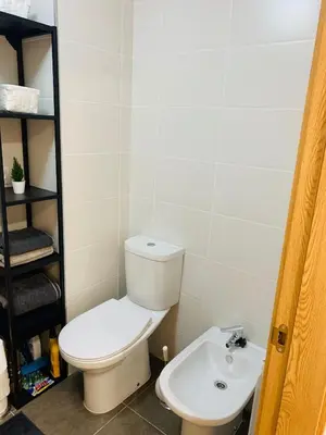 a bathroom with a toilet and a sink at Apartamentos LAMAROSA -PLAYA URBANA in Burela de Cabo