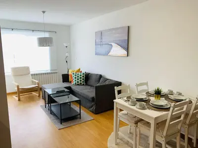 a living room with a couch and a table at Apartamentos LAMAROSA -PLAYA URBANA in Burela de Cabo