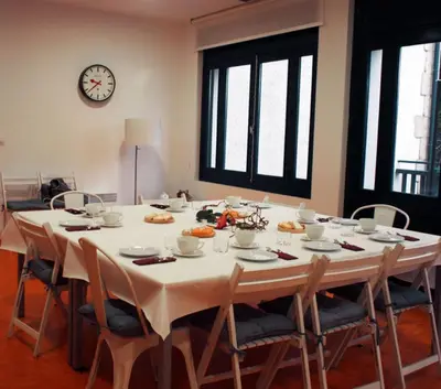 a large table with chairs and a clock on the wall at Peares Center Chalet in Carballedo