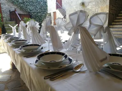 a table with white plates and napkins on it at Duerming Casa Vilamor in Vilamor