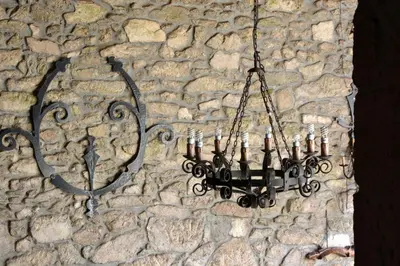 a chandelier hanging on a stone wall at Duerming Casa Vilamor in Vilamor
