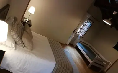 a bedroom with a white bed and a window at Duerming Casa Vilamor in Vilamor