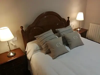 a bedroom with a bed with pillows and two lamps at Duerming Casa Vilamor in Vilamor