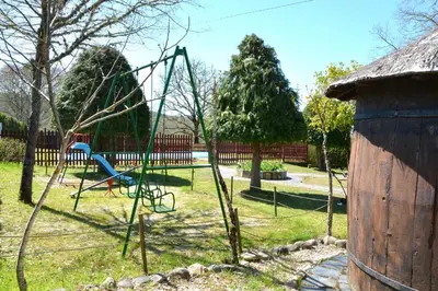 a playground with a swing set in a park at Duerming Casa Vilamor in Vilamor