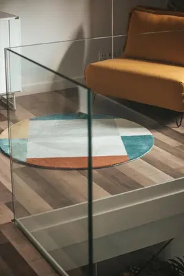 a glass table with a rug and a chair at ACASADETEO in Padrón