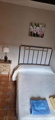 a bedroom with a bed and a table with a lamp at Casa Mariana in Lubián