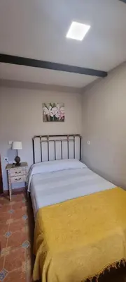 a bedroom with a large bed with a yellow blanket at Casa Mariana in Lubián