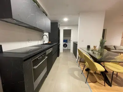 a kitchen with a black counter and a dining room at Oktheway Areal Terrace in Oleiros