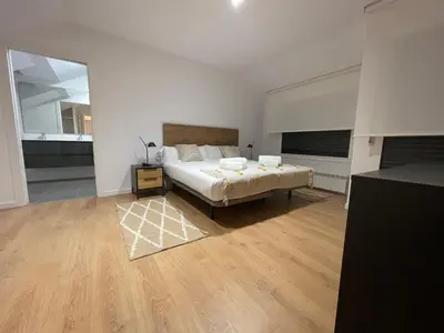 a large bedroom with a bed and a mirror at Oktheway Areal Terrace in Oleiros