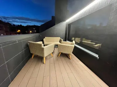 two chairs and a table on a balcony at night at Oktheway Areal Terrace in Oleiros
