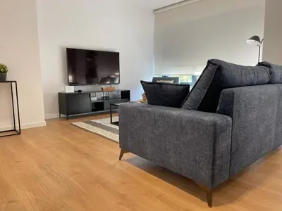 a living room with a couch and a flat screen tv at Oktheway Areal Terrace in Oleiros