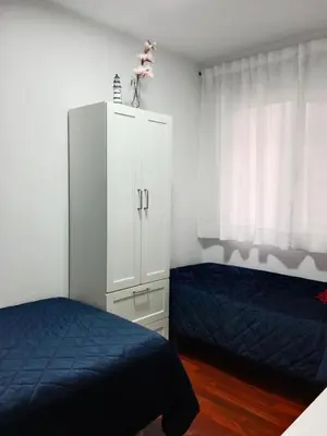 a bedroom with two beds and a white cabinet at Viveiro Histórico 3 in Viveiro