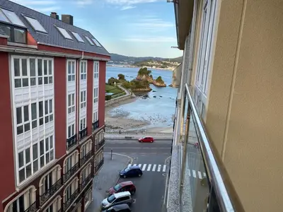 a view from the window of a building with a view of the ocean at Piso Vista os castelos in Viveiro