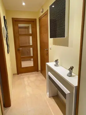a bathroom with a white sink and a wooden door at Piso Vista os castelos in Viveiro