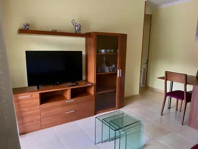 a living room with a entertainment center with a flat screen tv at Piso Vista os castelos in Viveiro