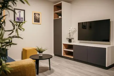 a living room with a flat screen tv on a wall at Hotel Lux Melide in Melide