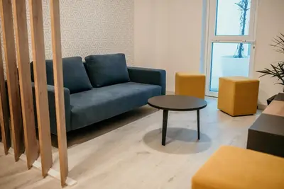 a living room with a blue couch and a table at Hotel Lux Melide in Melide