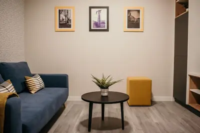 a living room with a blue couch and a table at Hotel Lux Melide in Melide