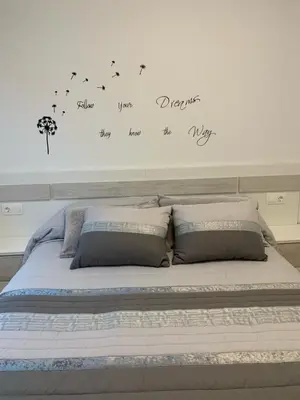 a bedroom with a bed with words on the wall at Apartamento Porta da Vila in Viveiro