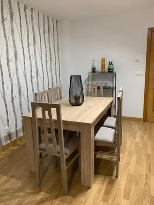 a wooden table with chairs and a lamp on it at Apartamento Porta da Vila in Viveiro