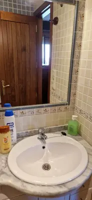 a bathroom counter with a sink and a mirror at Casa Cesar in Lubián