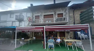 a group of people sitting at tables in front of a building at Casa Cesar in Lubián