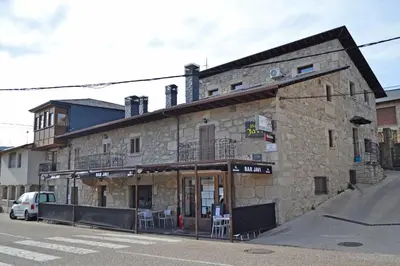 an old stone building on the corner of a street at Hotel Rural Val Dos Pigarros in Lubián